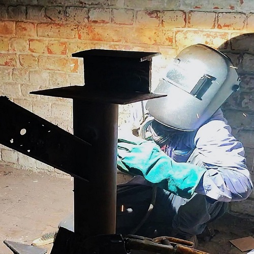 A skilled welder performing precision welding with a torch, creating a brilliant fiery glow, symbolizing craftsmanship and excellence in industries like Oil & Gas, Chemicals, and Electro-Mechanical EPC projects